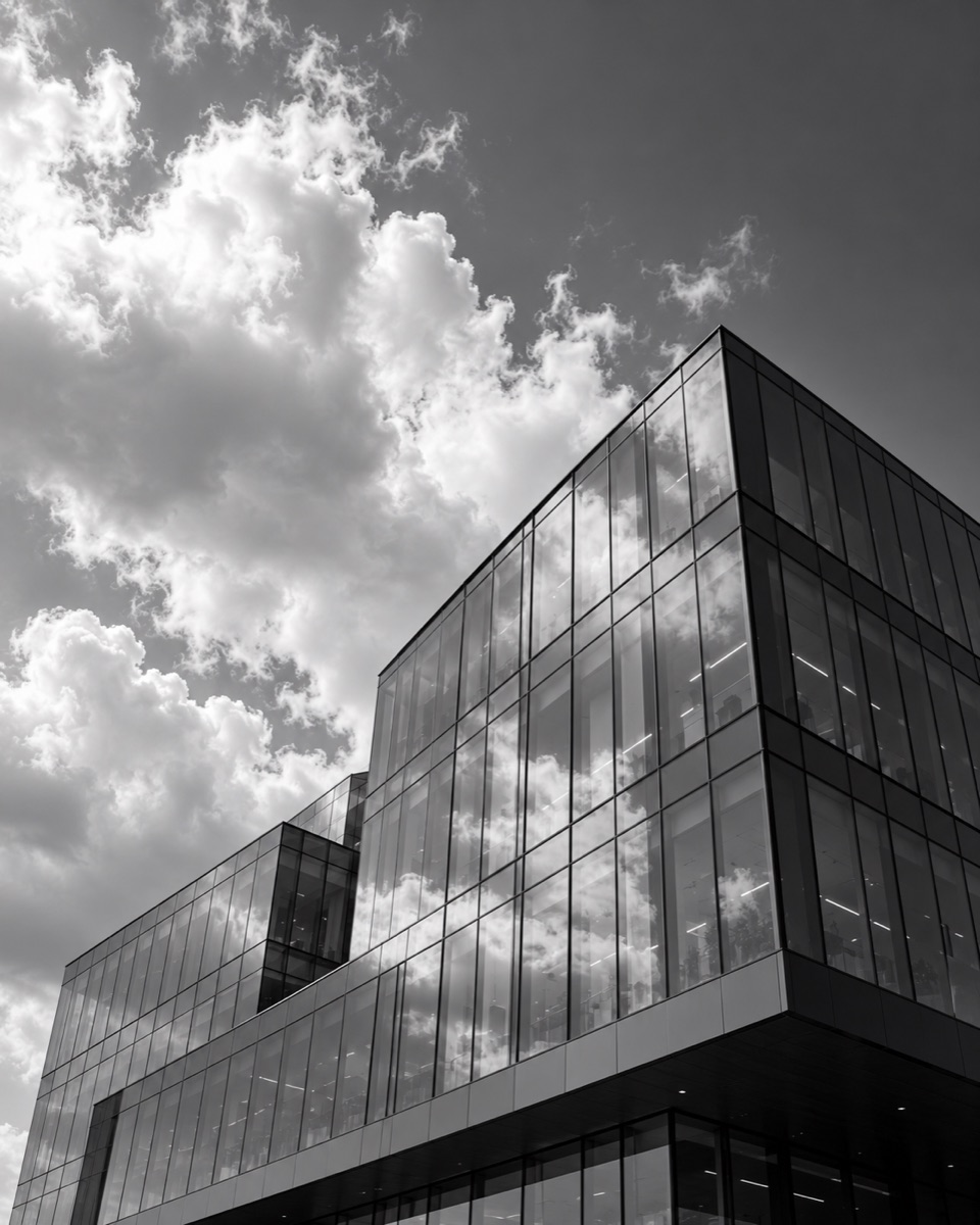 Monochrome glass building beneath clouds